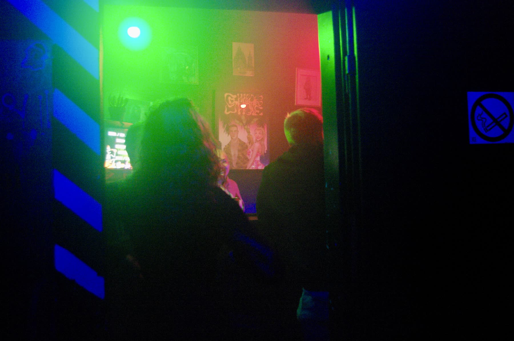 Club entrance glow and crowd in red and green light